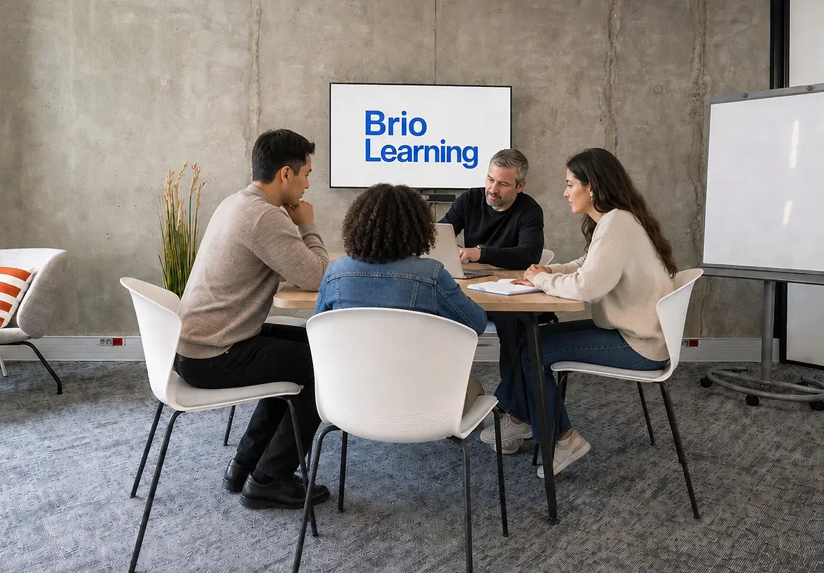 Quatre personnes en session de travail autour d'une table, dans une salle Brio Learning
