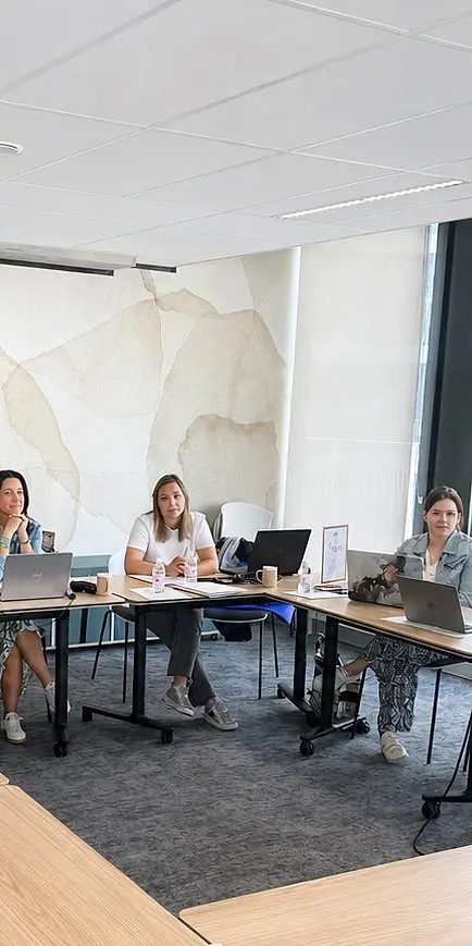 Des participants suivent une session devant leur ordinateur portable, en salle